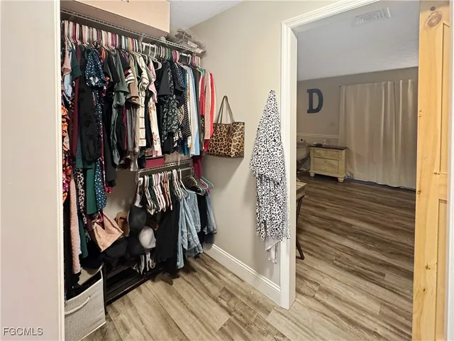 a view of walk in closet with clothes and shoes