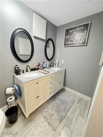 a bathroom with a granite countertop double vanity sink and a mirror