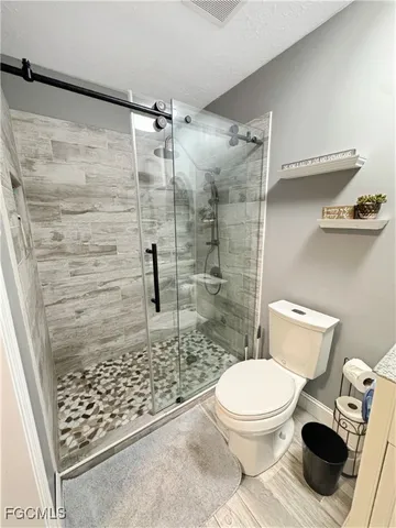 a bathroom with a toilet and a shower