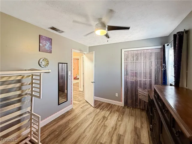 a view of a hallway with entryway and wooden floor