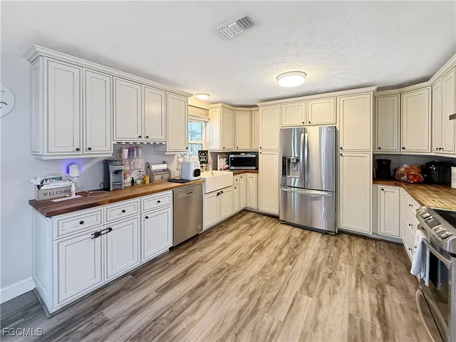 a kitchen with granite countertop a refrigerator sink and cabinets