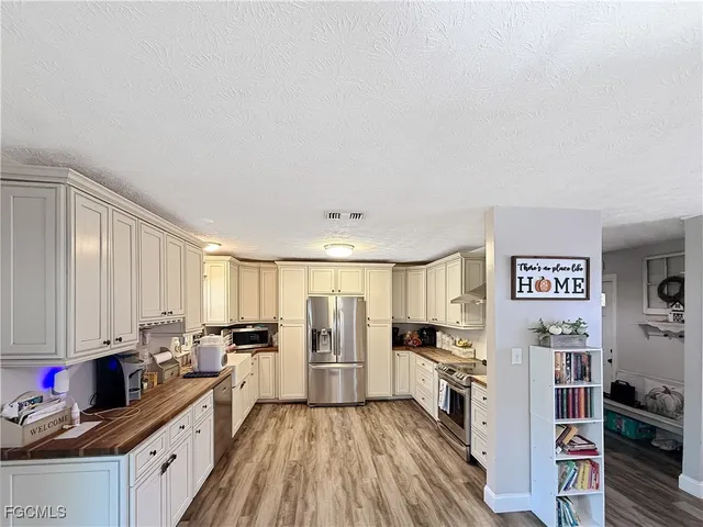 a kitchen with stainless steel appliances a refrigerator and a stove top oven