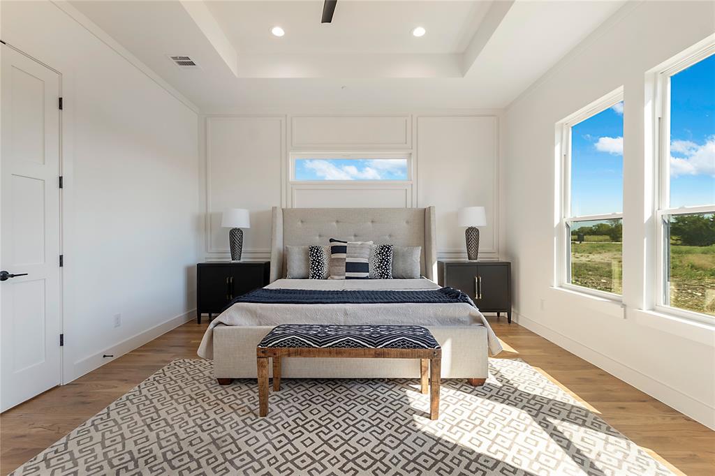 430 Whispering Way Red Oak, TX 75154 - Photo 37 of 40 Spacious room featuring wood-finish flooring, a tray ceiling with recessed lighting, an accent wall with decorative molding, and multiple windows