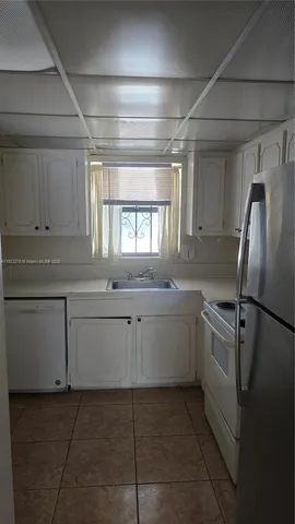 a kitchen with white cabinets and white appliances
