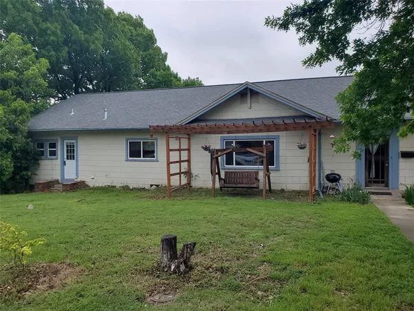 a backyard of a house with table and chairs