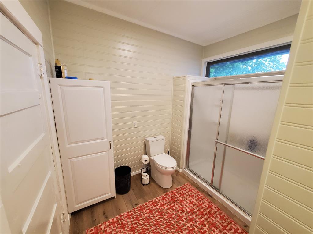 300 North Church Street Decatur, TX 76234 - Photo 15 of 19 a white toilet sitting next to a shower curtain