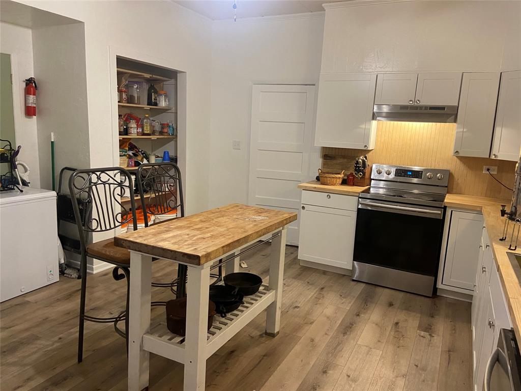 300 North Church Street Decatur, TX 76234 - Photo 6 of 19 a kitchen with a stove a refrigerator and a dining table