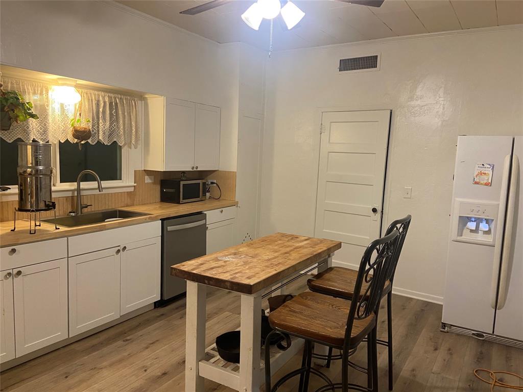 300 North Church Street Decatur, TX 76234 - Photo 7 of 19 a kitchen with a table chairs sink and cabinets