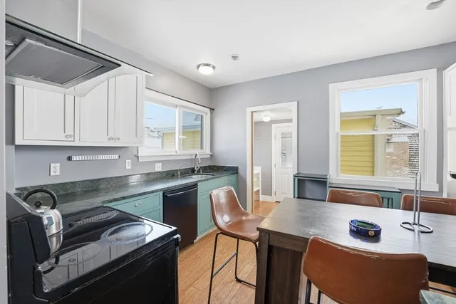 a kitchen with a table chairs sink and cabinets