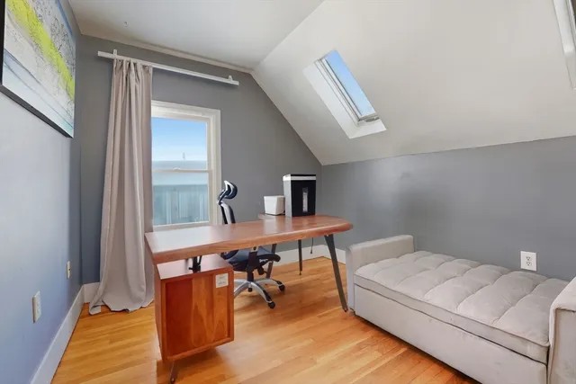 a view of a workspace with furniture and wooden floor