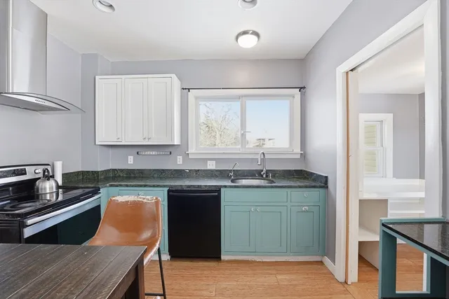a kitchen with stainless steel appliances granite countertop a sink stove and cabinets