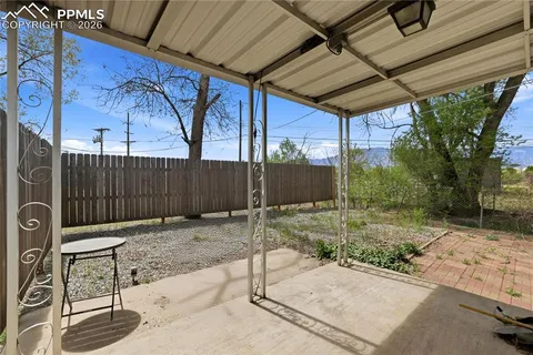 a view of a backyard with table and chairs with wooden fence