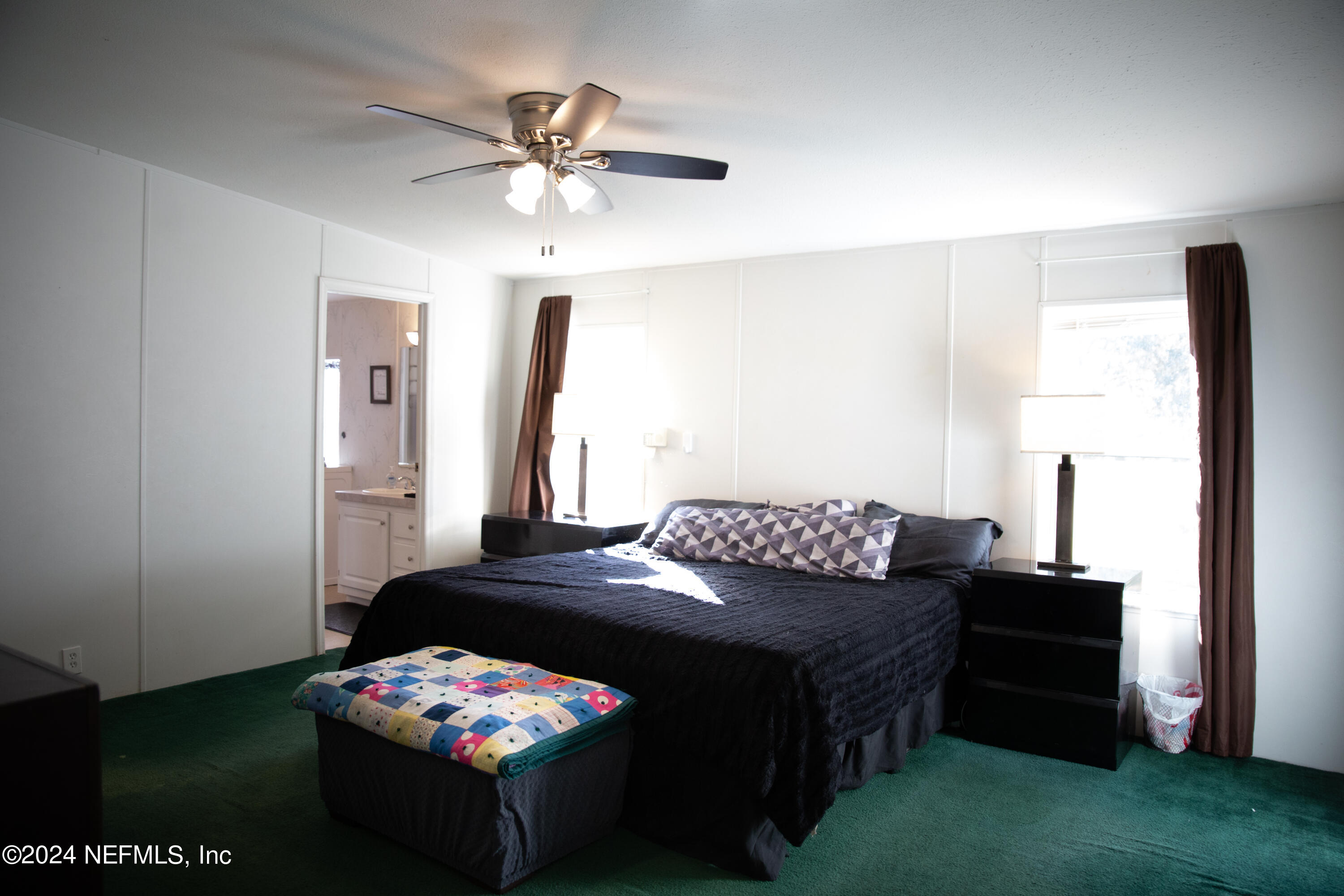 5518 Long Branch Cemetery Road Jacksonville, FL 32234 - Photo 15 of 22 a bedroom with a bed and a chandelier