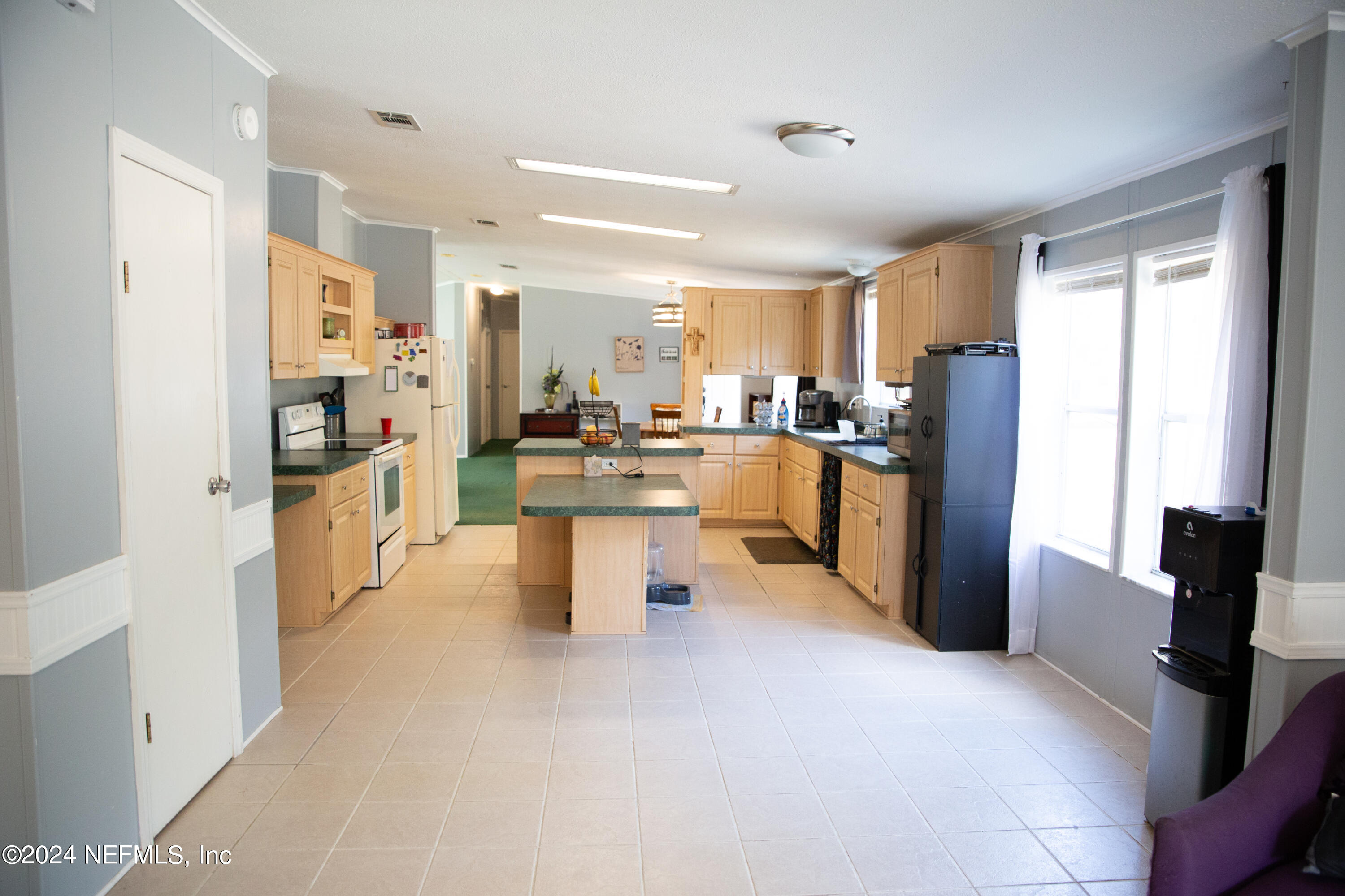 5518 Long Branch Cemetery Road Jacksonville, FL 32234 - Photo 10 of 22 a kitchen with stainless steel appliances kitchen island granite countertop a refrigerator and a sink