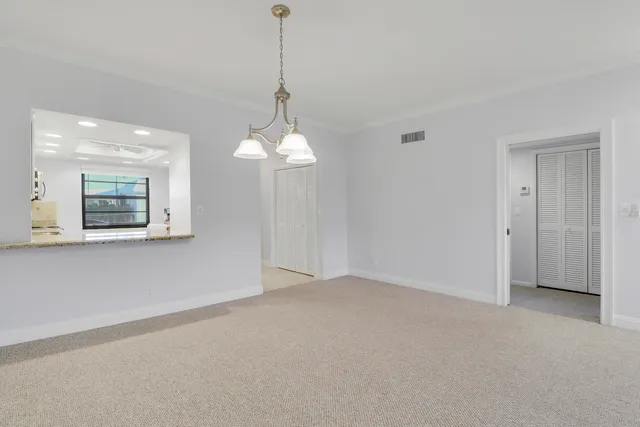 a view of a room with a chandelier fan and windows