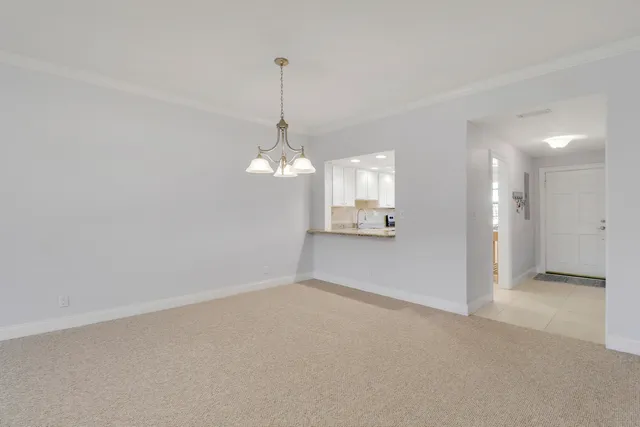 a view of a room with a chandelier fan and windows