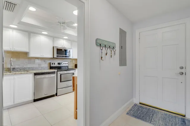 a kitchen with white cabinets and white appliances