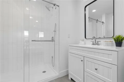 a bathroom with a shower sink and mirror