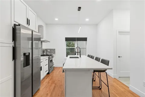 a kitchen with stainless steel appliances a refrigerator and a stove top oven