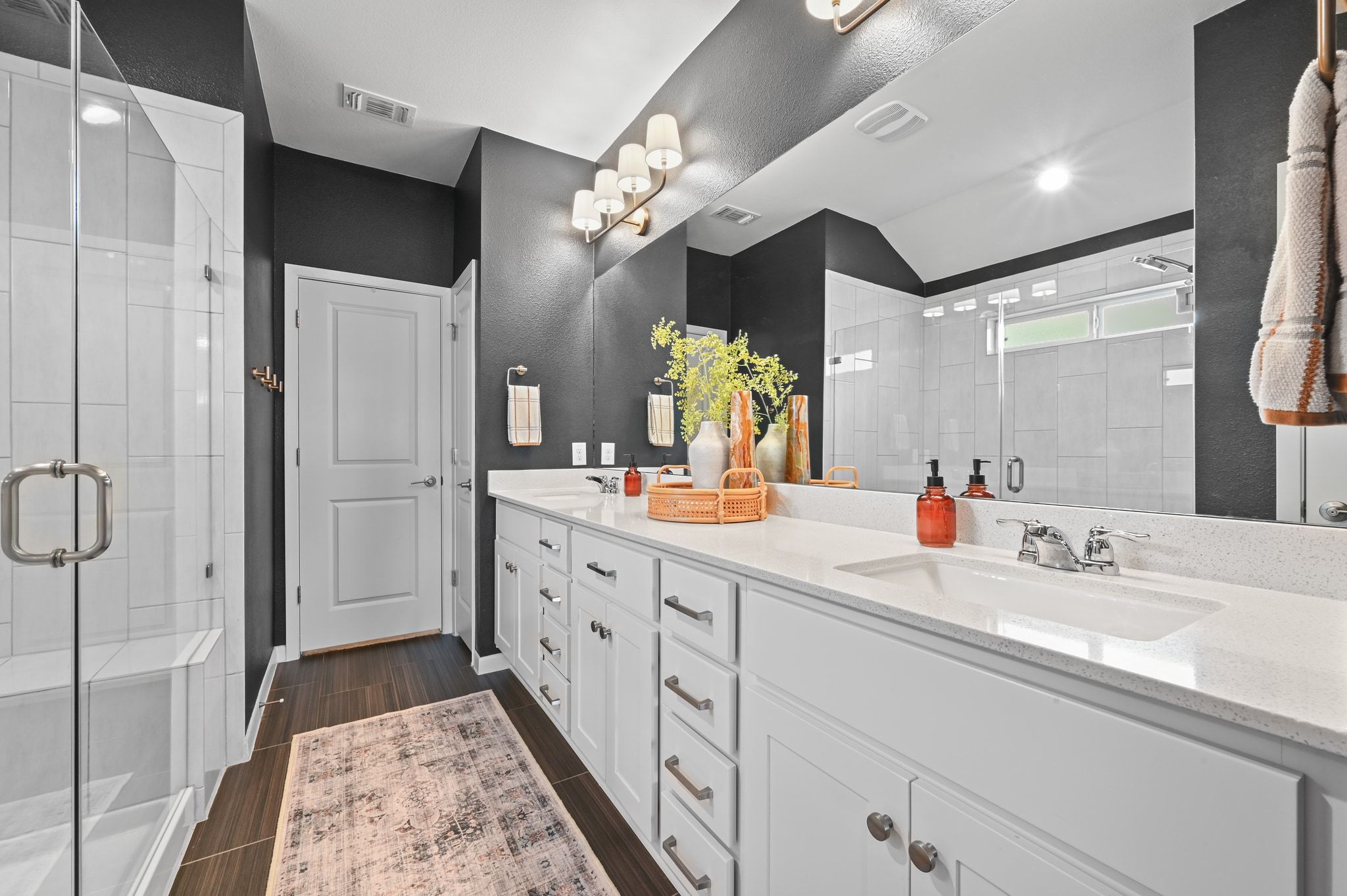 16620 Sumptuous Drive Manor, TX 78653 - Photo 19 of 40 Completely renovated primary bathroom featuring seamless glass shower, double vanity, designer lighting, and fresh paint.