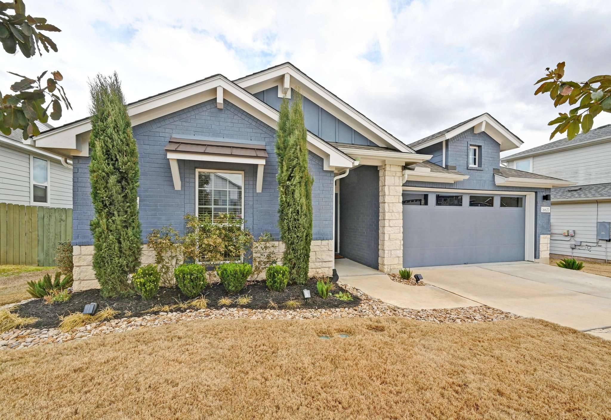 16620 Sumptuous Drive Manor, TX 78653 - Photo 2 of 40 View of front of home featuring board and batten siding, concrete driveway, and a 2 car garage