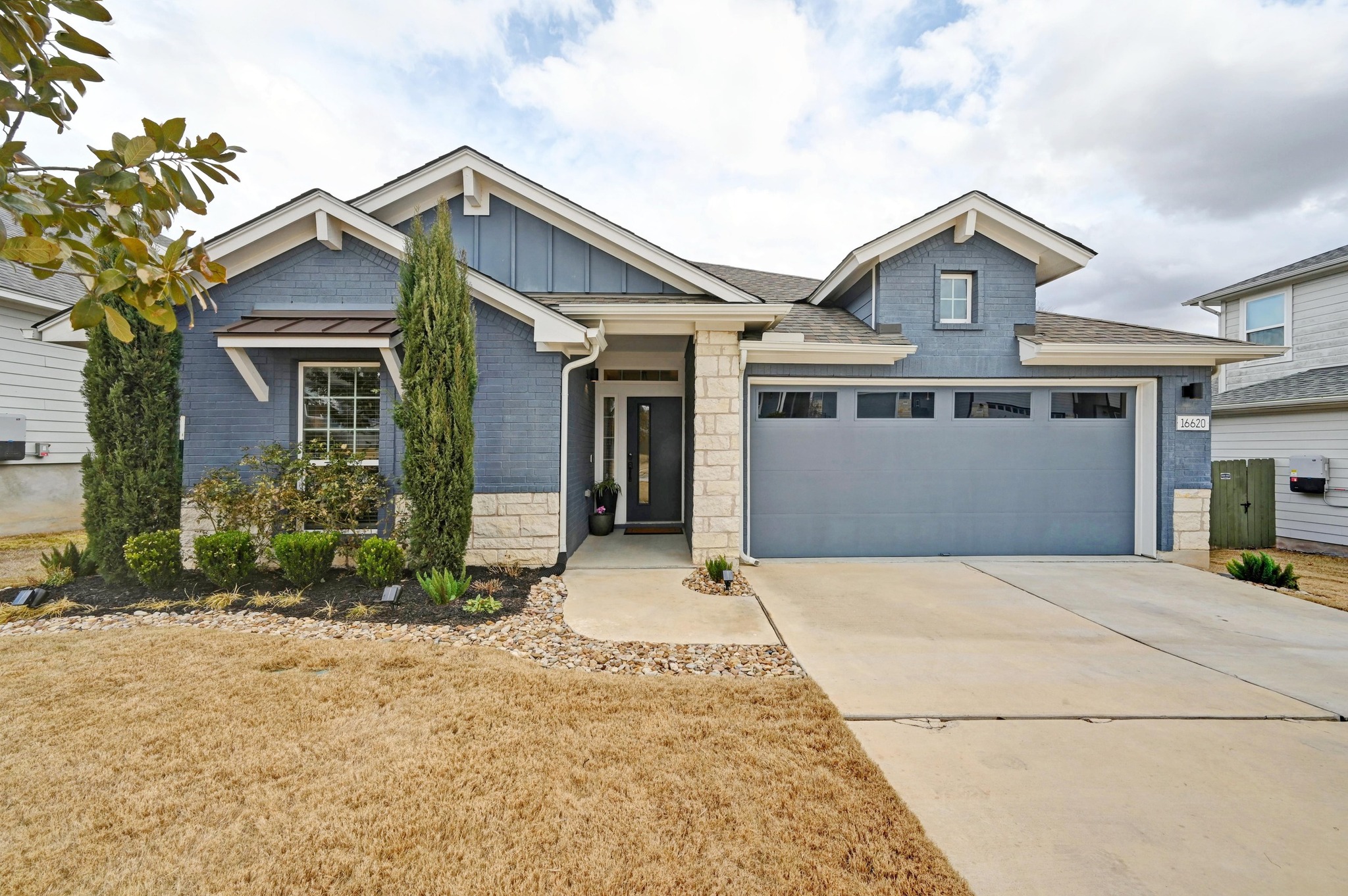 16620 Sumptuous Drive Manor, TX 78653 - Photo 32 of 40 Craftsman-style home featuring board and batten siding, stone siding, a front landscaping, and two car garage
