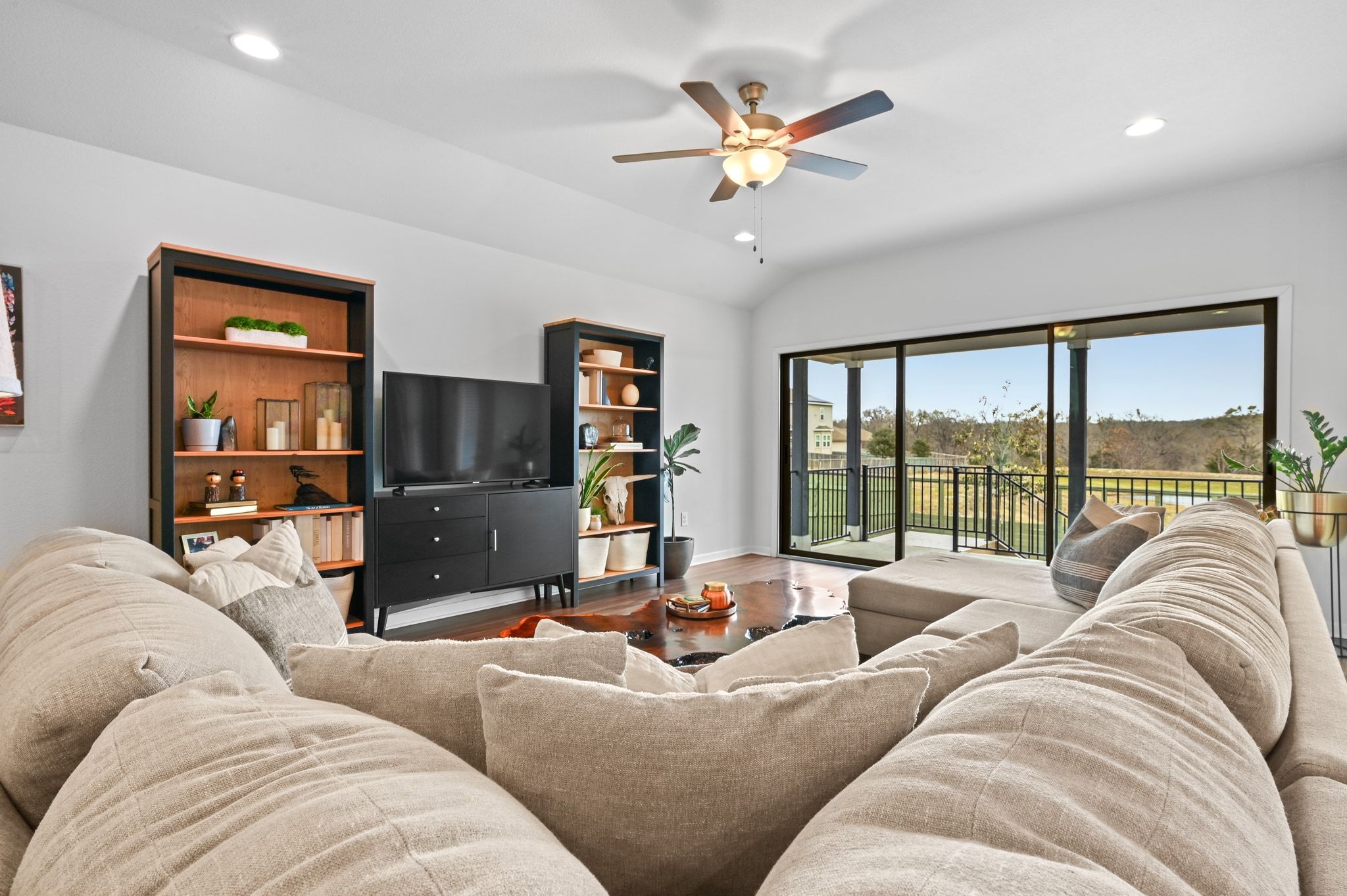 16620 Sumptuous Drive Manor, TX 78653 - Photo 9 of 40 Living room featuring recessed lighting, wood finished vinyl floors, and vaulted ceiling with views of pond and greenbelt.