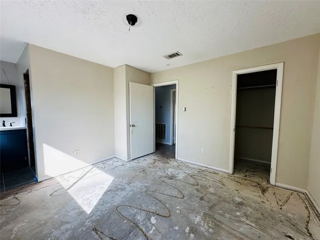 a view of a hallway with a white cabinet and a refrigerator