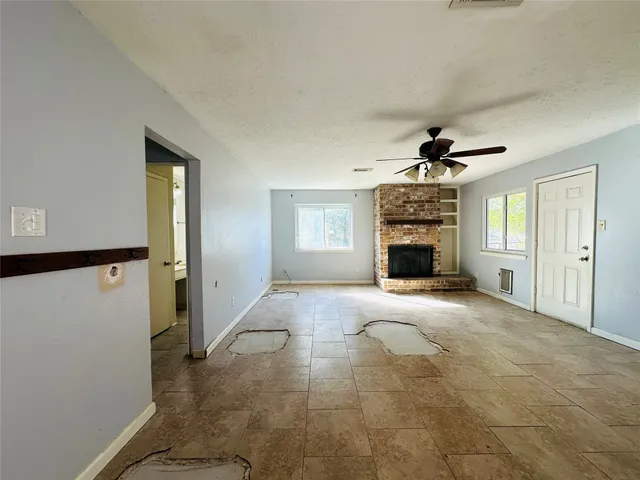 a view of a livingroom with a fireplace and window