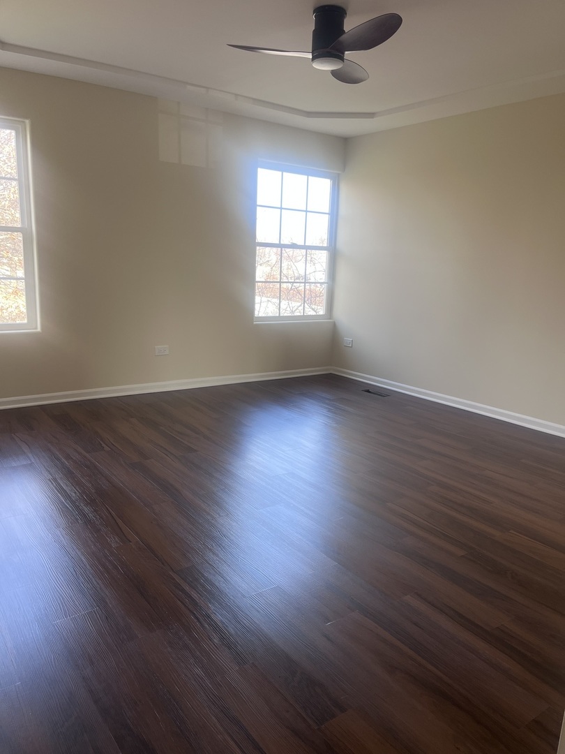 547 Goodwin Drive Bolingbrook, IL 60440 - Photo 13 of 36 an empty room with wooden floor and windows