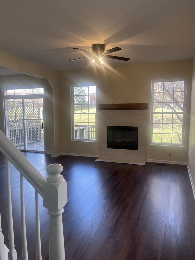 547 Goodwin Drive Bolingbrook, IL 60440 - Photo 4 of 36 an empty room with wooden floor fireplace and windows