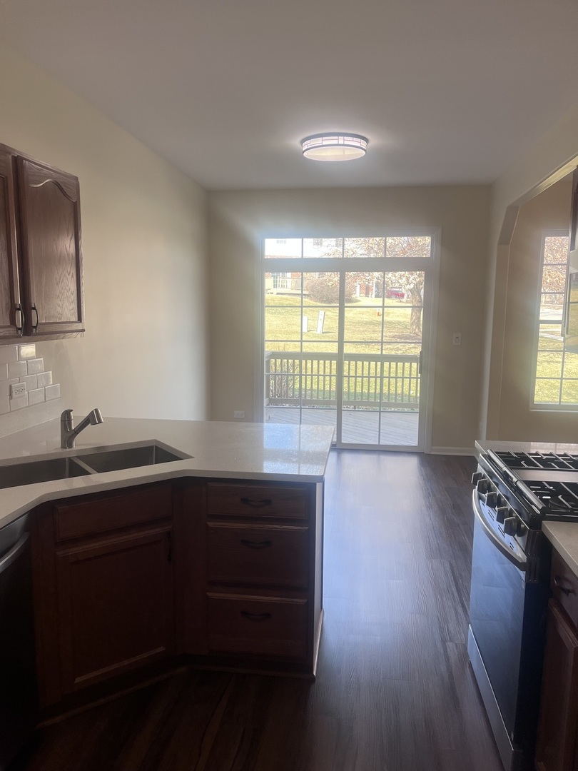 547 Goodwin Drive Bolingbrook, IL 60440 - Photo 8 of 36 a kitchen with a sink a stove a window and cabinets