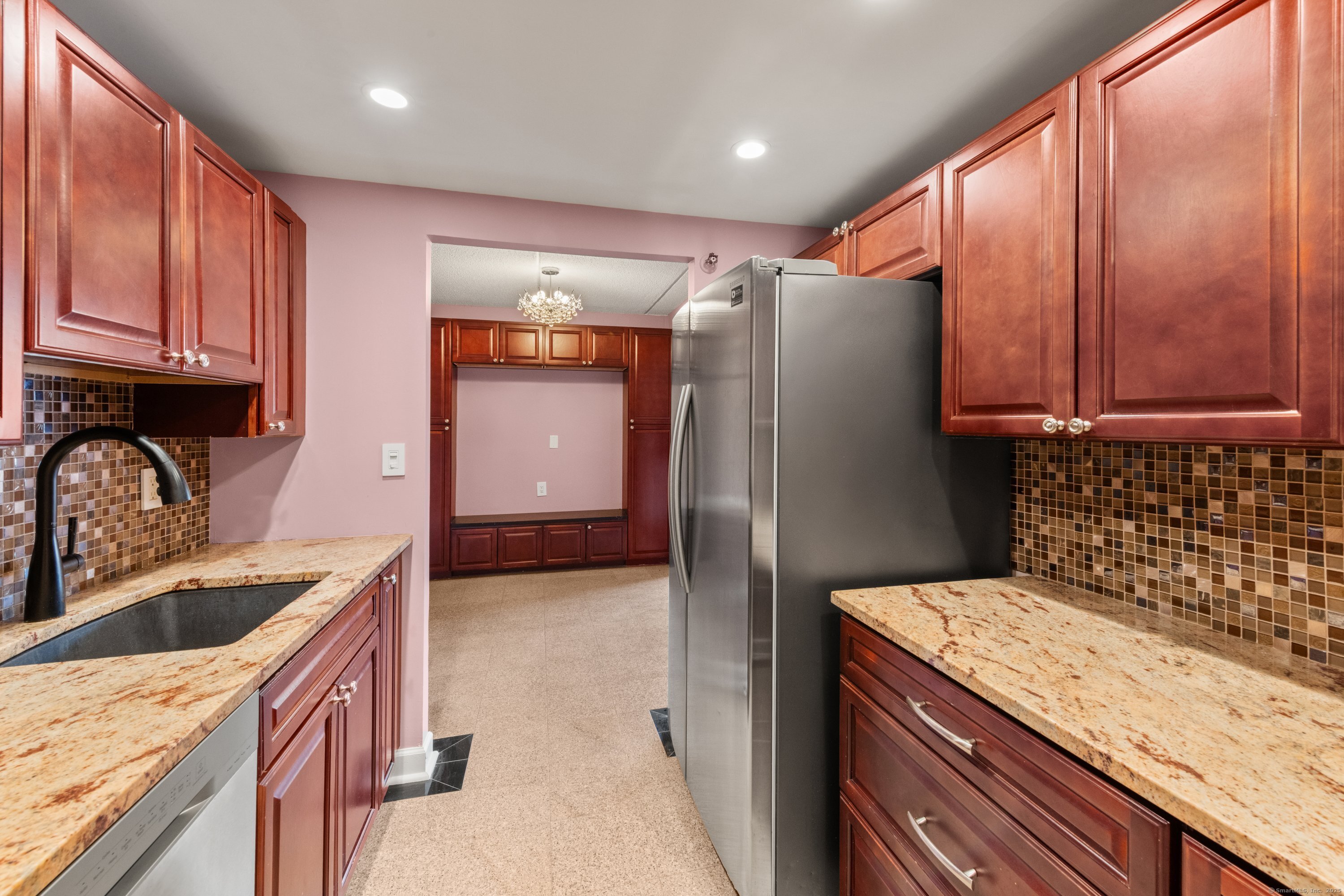143 Hoyt Street, Unit 1A Stamford, CT 06905 - Photo 17 of 32 a kitchen with granite countertop a sink a refrigerator and cabinets