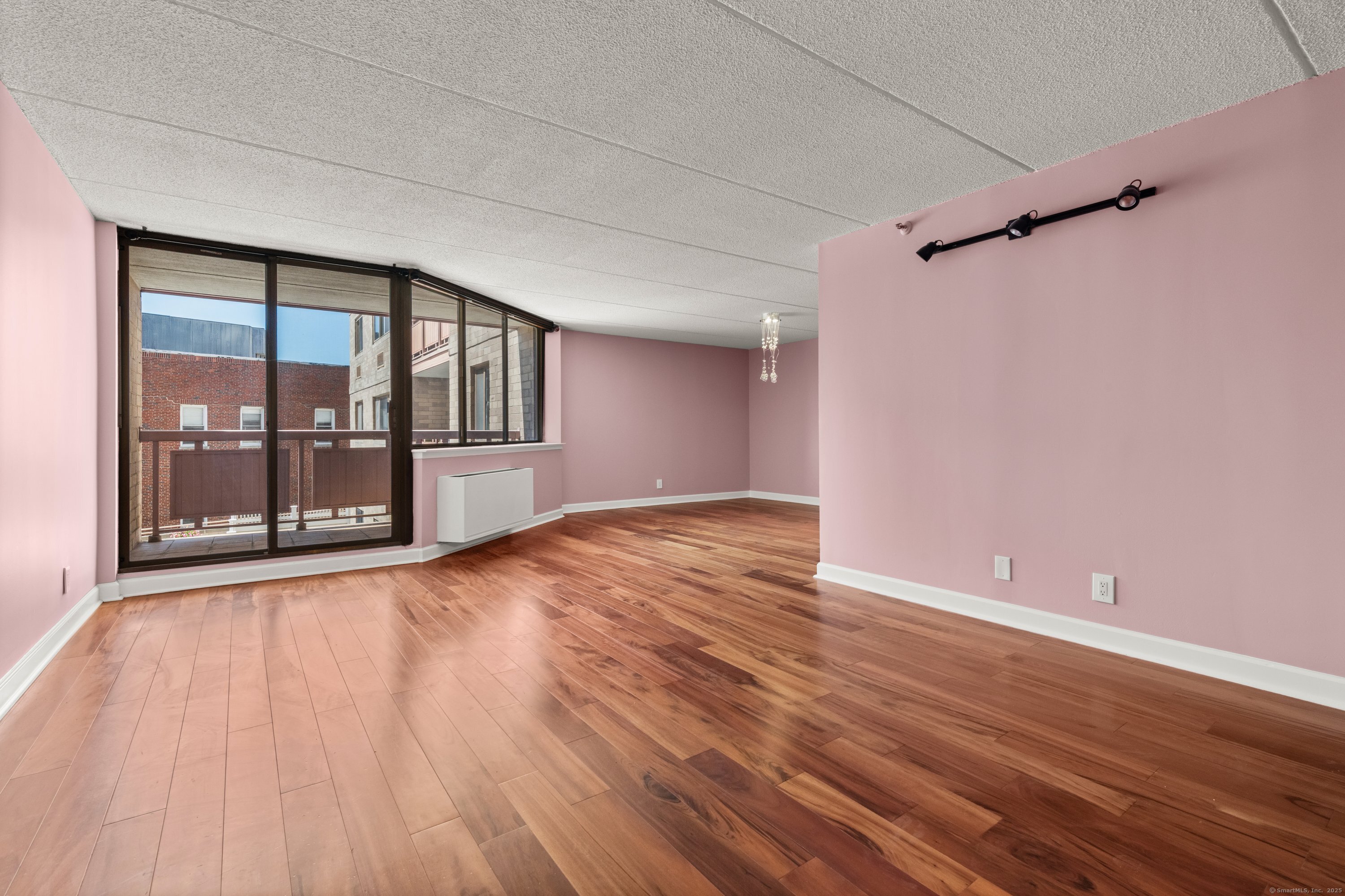 143 Hoyt Street, Unit 1A Stamford, CT 06905 - Photo 7 of 32 a view of an empty room with wooden floor and a window
