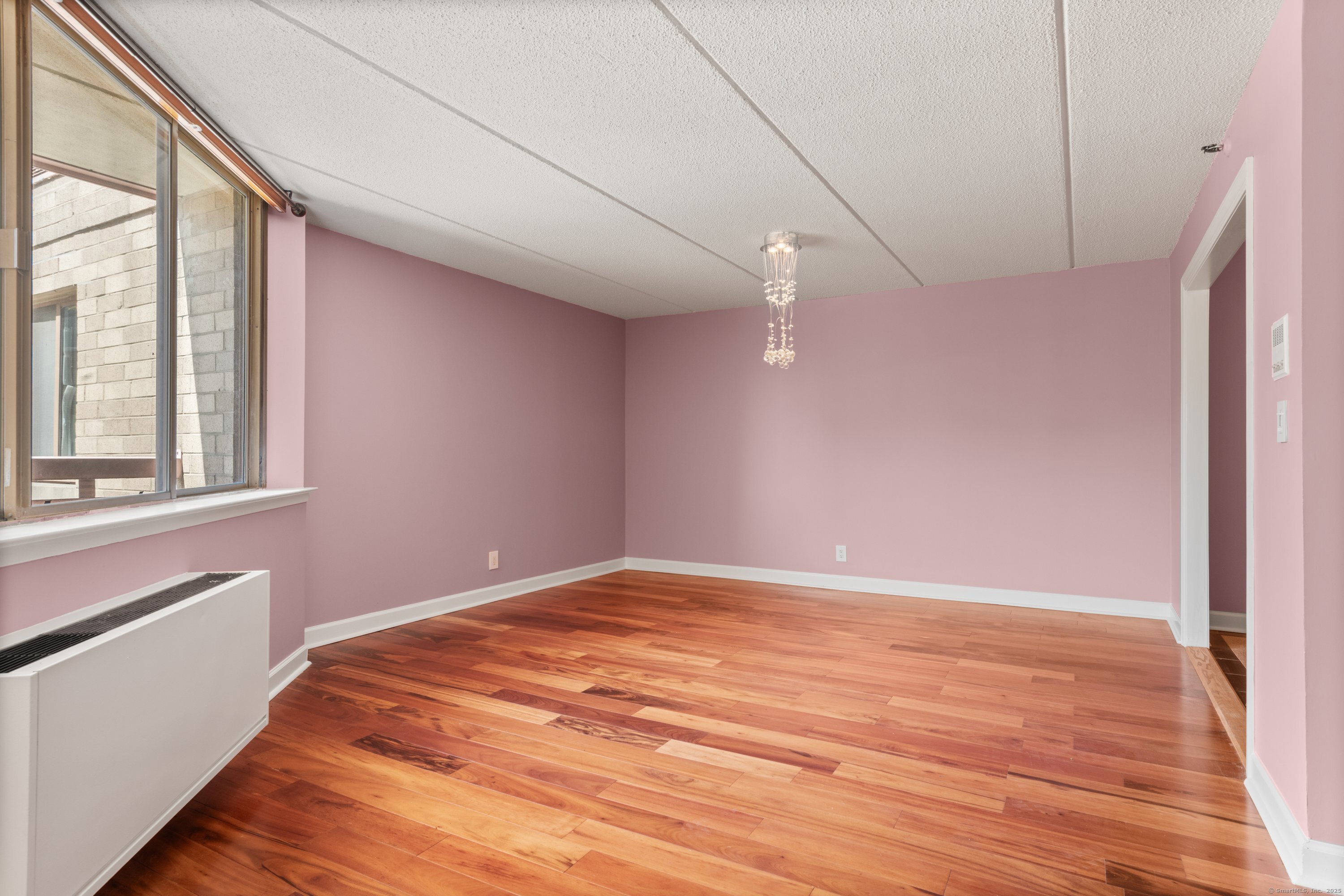 143 Hoyt Street, Unit 1A Stamford, CT 06905 - Photo 10 of 32 a view of empty room with wooden floor and fan