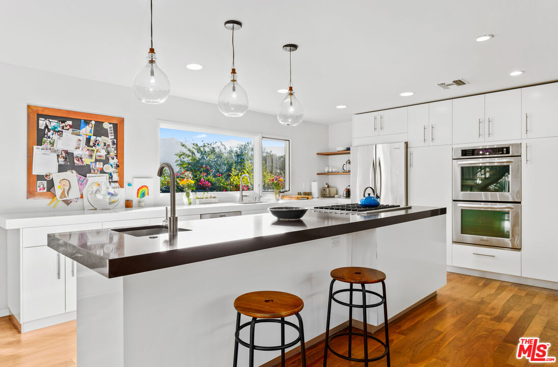 13501 Bayliss Road Los Angeles, CA 90049 - Photo 11 of 33 a large kitchen with a table and chairs in it