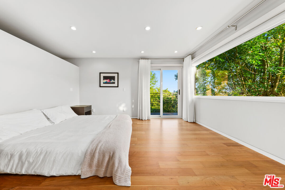 13501 Bayliss Road Los Angeles, CA 90049 - Photo 14 of 33 a spacious bedroom with a large bed and a large window