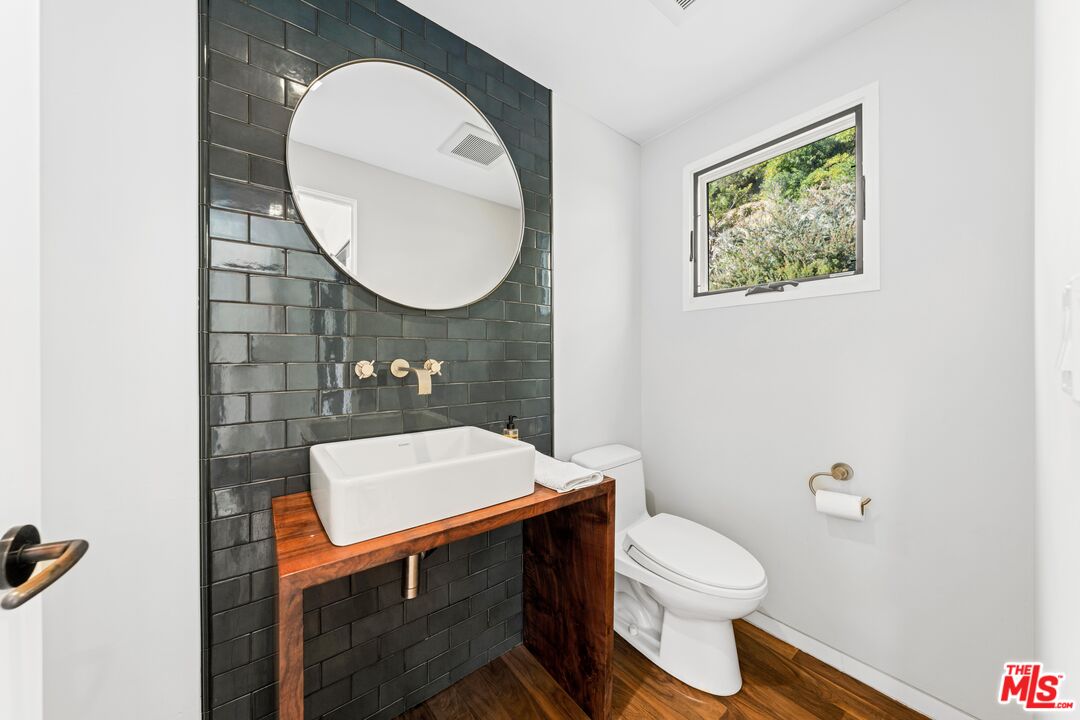 13501 Bayliss Road Los Angeles, CA 90049 - Photo 24 of 33 a bathroom with a toilet a sink and a mirror
