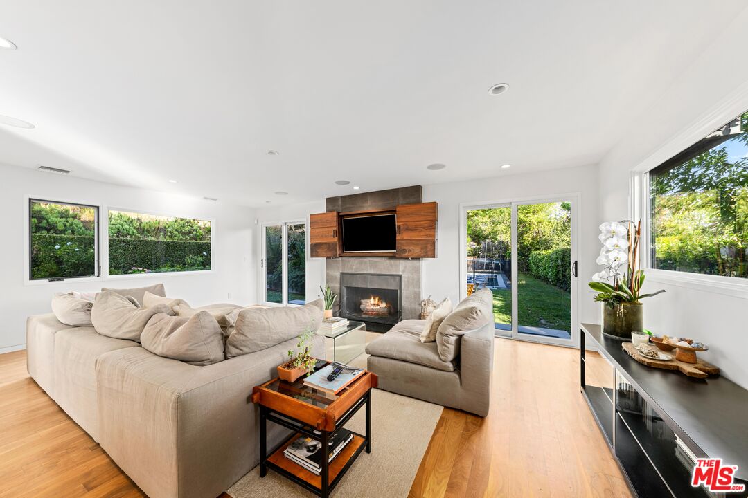 13501 Bayliss Road Los Angeles, CA 90049 - Photo 3 of 33 a living room with furniture fireplace and a flat screen tv