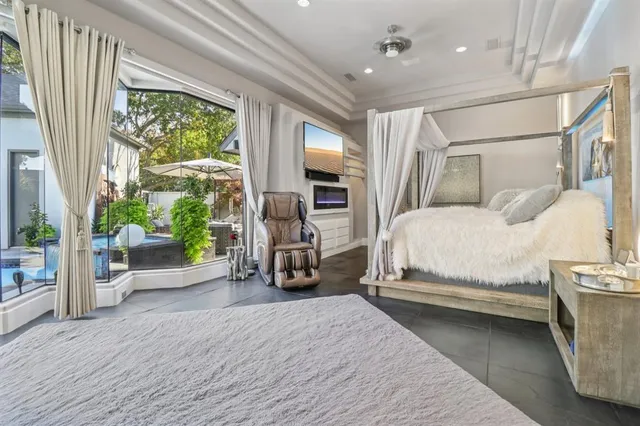 a bedroom with a bed couch and a large window