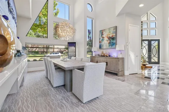 a kitchen with stainless steel appliances a stove a sink dishwasher and a dining table with wooden floor