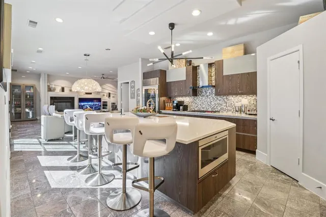 a kitchen with stainless steel appliances kitchen island granite countertop a table and chairs in it