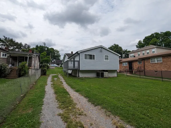 a aerial view of a house next to a big yard and large trees