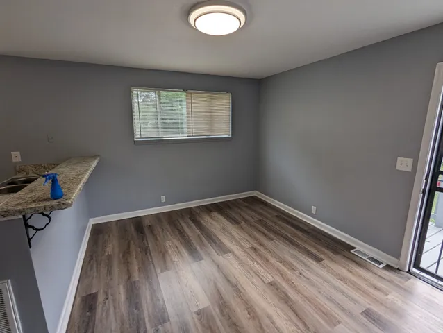 a view of a room with wooden floor and white walls