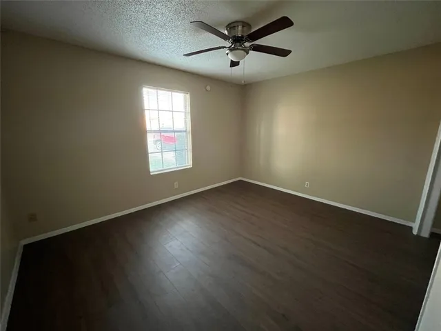 a view of a big room with wooden floor and windows