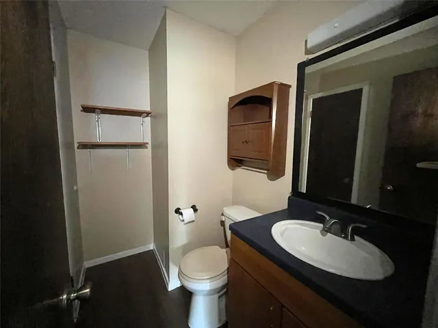 a bathroom with a granite countertop sink toilet and mirror