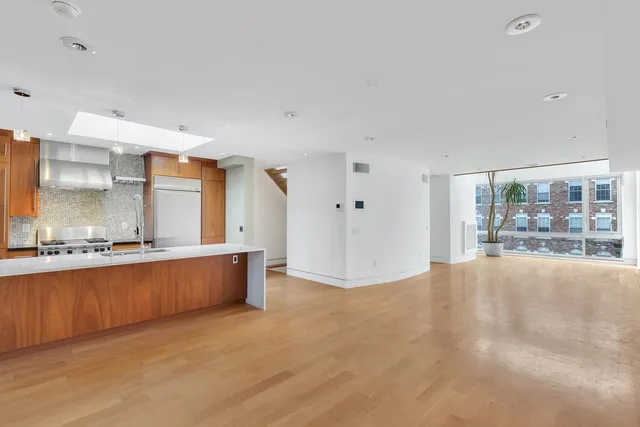 a large white kitchen with granite countertop a sink and white cabinets