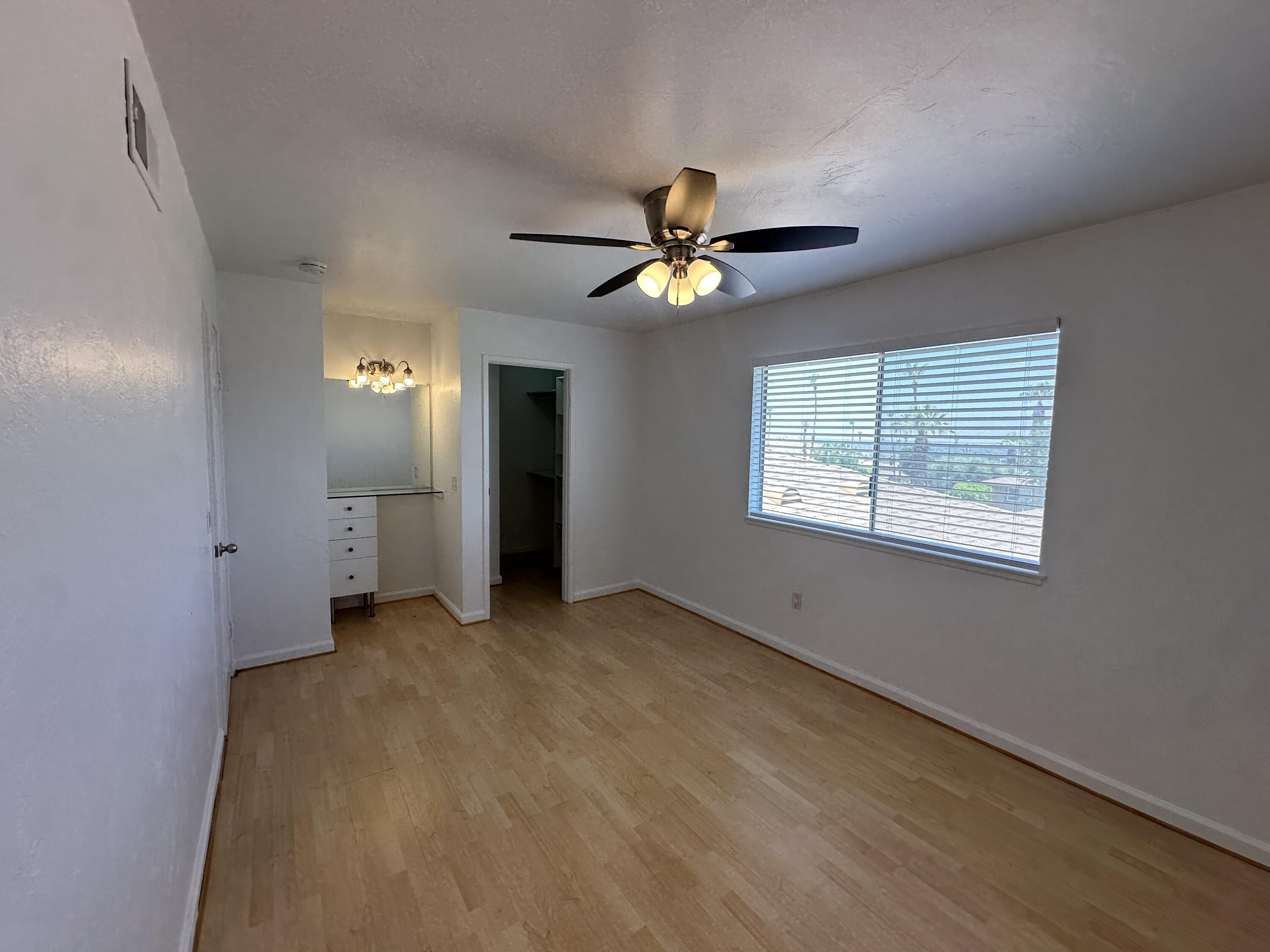 72631 Thrush Road, Unit 2 Palm Desert, CA 92260 - Photo 12 of 20 an empty room with chandelier fan and windows