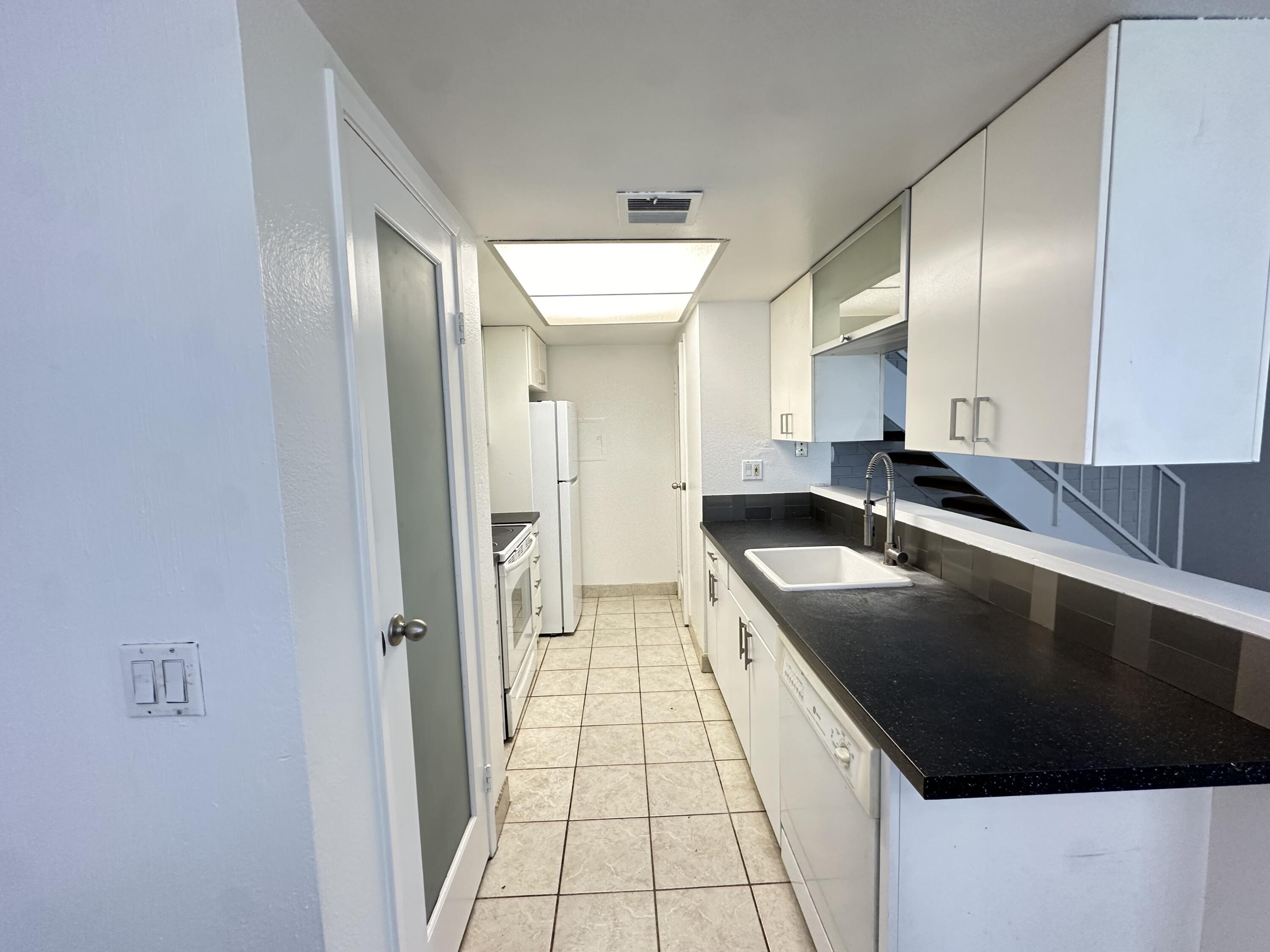 72631 Thrush Road, Unit 2 Palm Desert, CA 92260 - Photo 6 of 20 a large white kitchen with a stove a sink and a refrigerator