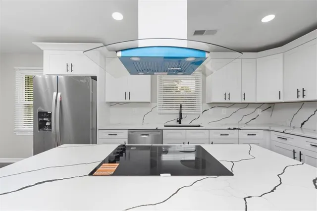 a kitchen with granite countertop a sink a counter space appliances and cabinets